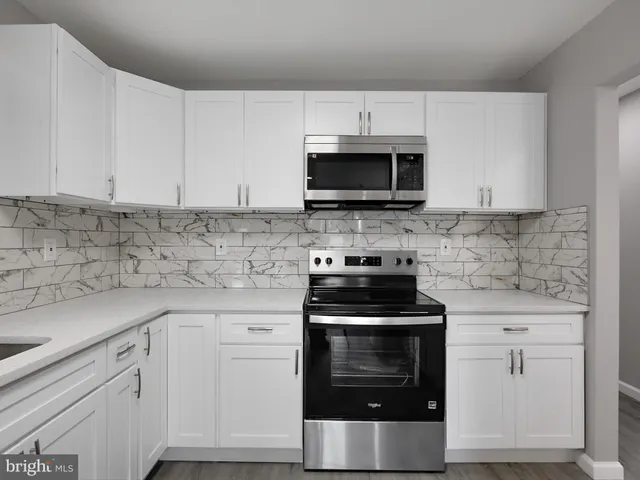 a kitchen with cabinets stainless steel appliances a sink and a microwave