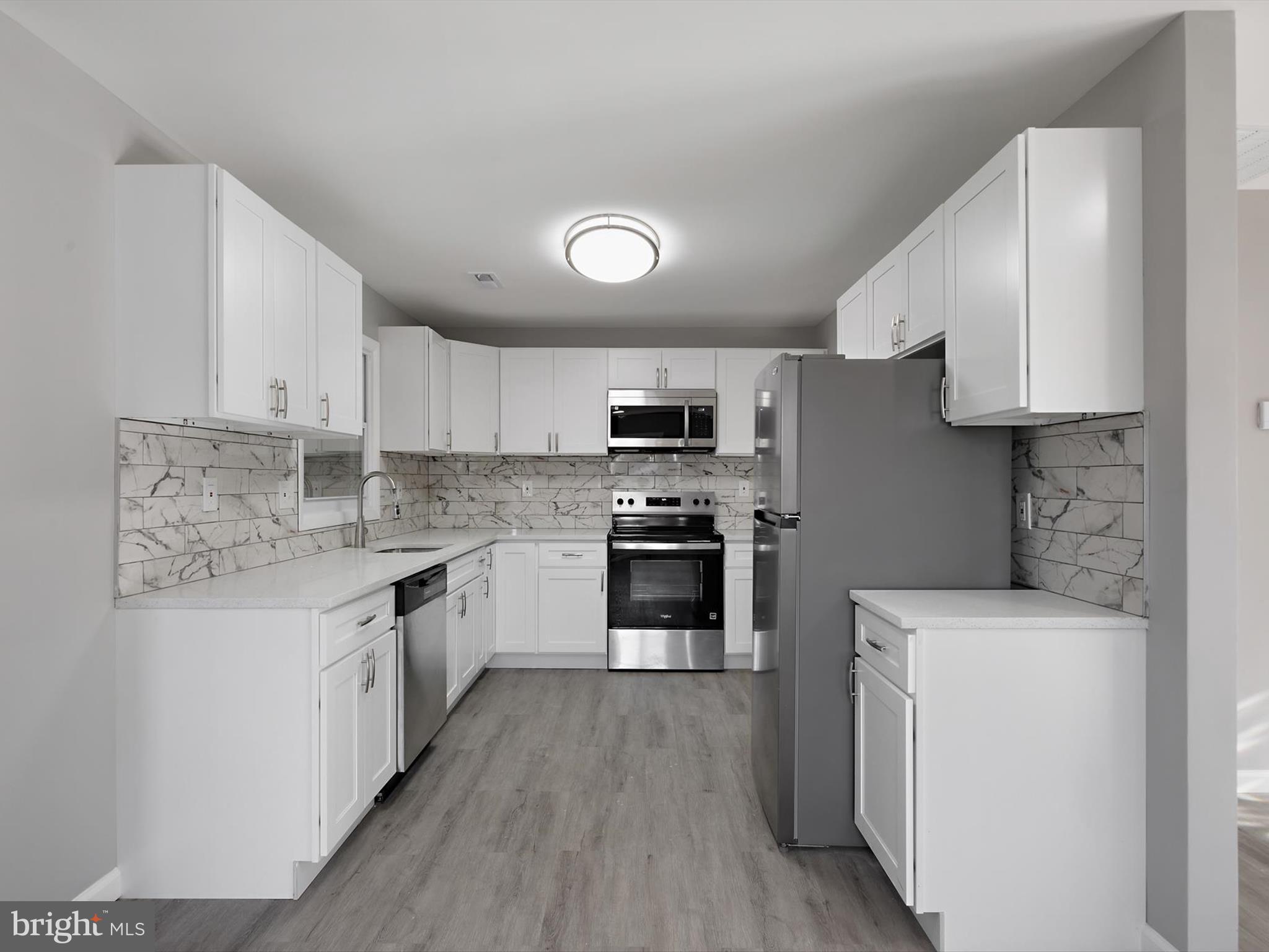 8635 Emory Grove Road Gaithersburg, MD 20877 - Photo 4 of 38 a kitchen with granite countertop a sink a counter top space stainless steel appliances and cabinets