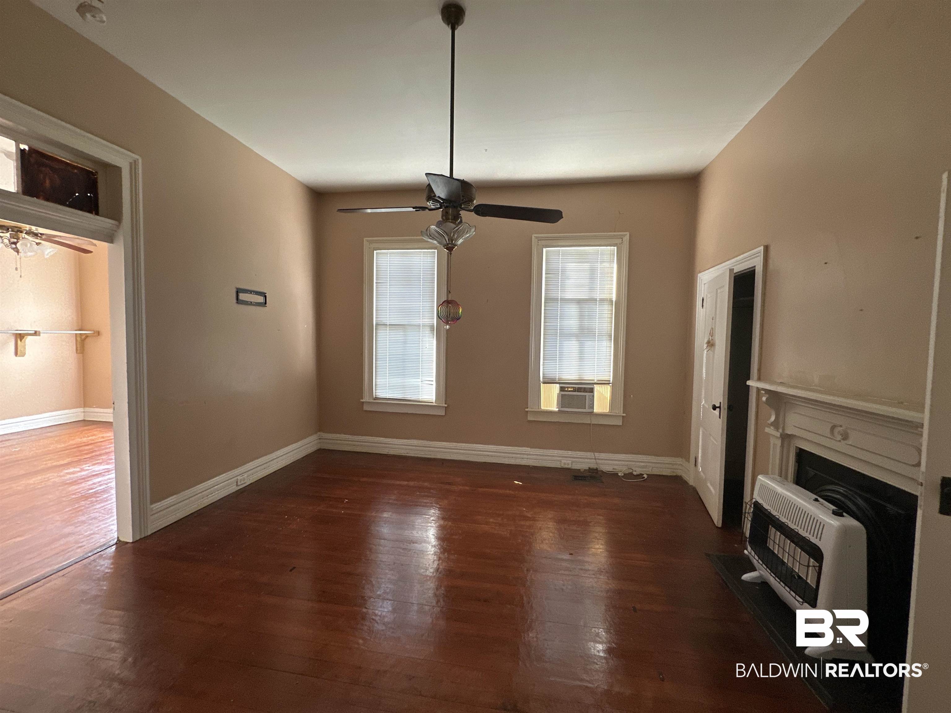 1119 Old Shell Road Mobile, AL 36604 - Photo 4 of 22 Unfurnished living room featuring heating unit, dark hardwood / wood-style flooring, and ceiling fan