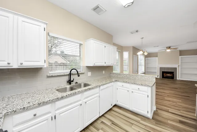 a kitchen with granite countertop a sink stainless steel appliances and cabinets