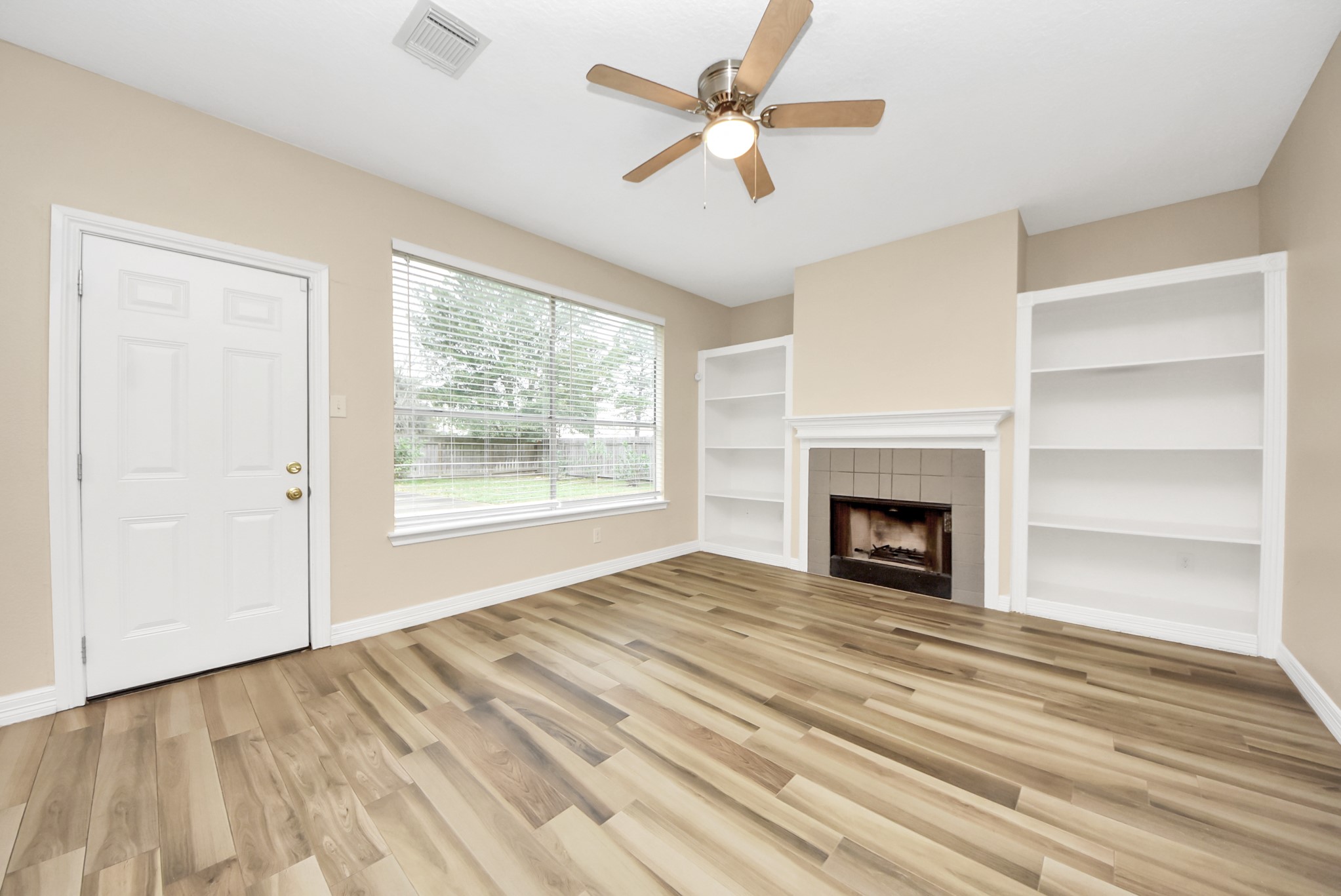 1702 Park Ridge Drive Katy, TX 77450 - Photo 8 of 30 a view of an empty room with a fireplace and a window