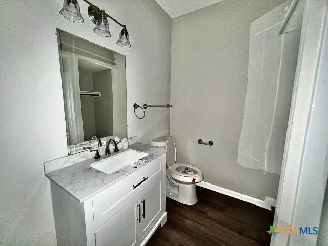 a bathroom with a granite countertop sink toilet and mirror