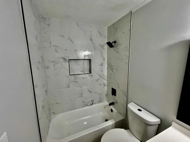 a white toilet sitting next to a bathroom sink