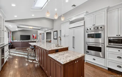 a kitchen with stainless steel appliances kitchen island granite countertop a stove and a sink