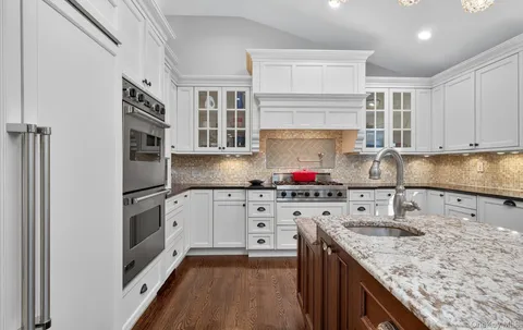 a kitchen with stainless steel appliances granite countertop a stove sink and cabinets