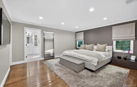 a spacious bedroom with a large bed and wooden floor