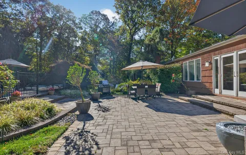 a view of a patio with table and chairs under an umbrella