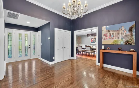 a view of an empty room with kitchen and window