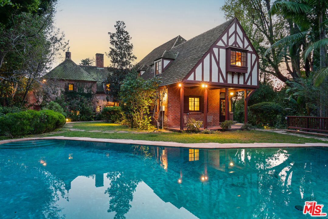 a view of a house with swimming pool and a yard