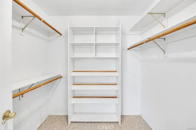 a view of walk in closet with empty racks