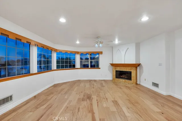 a view of empty room with wooden floor and fireplace