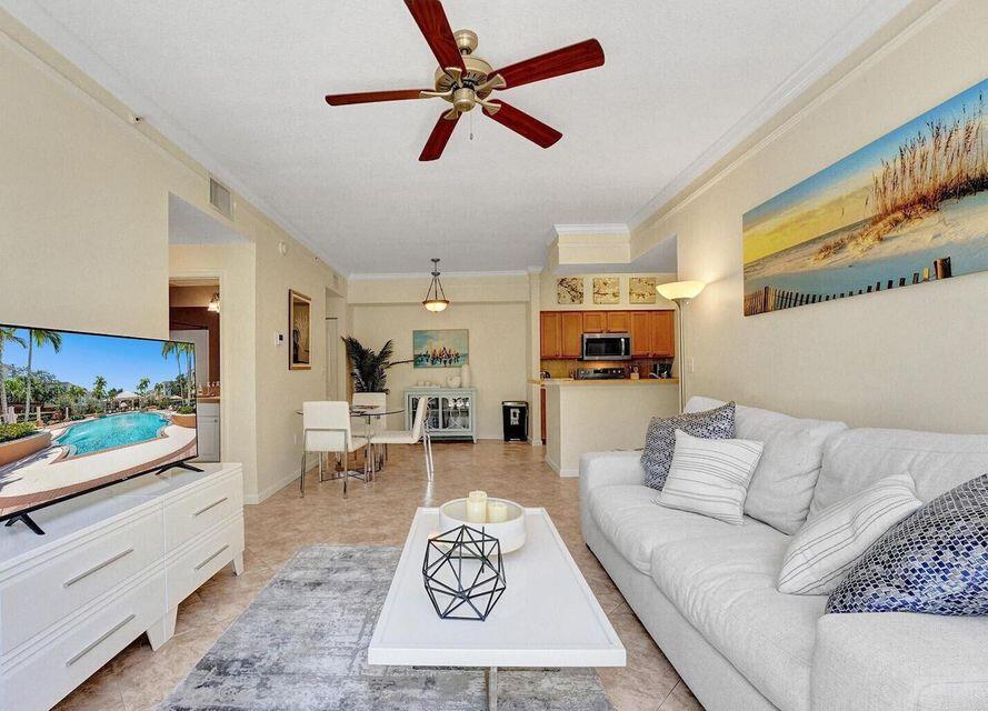 9857 Baywinds Boulevard, Unit 9302 West Palm Beach, FL 33411 - Photo 14 of 45 a living room with furniture and a flat screen tv