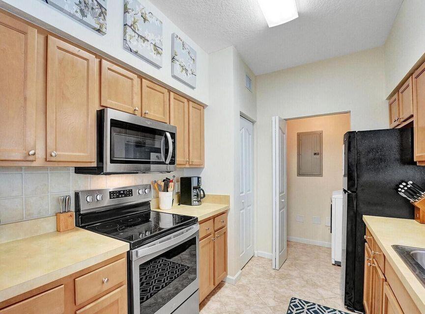 9857 Baywinds Boulevard, Unit 9302 West Palm Beach, FL 33411 - Photo 18 of 45 a kitchen with stainless steel appliances a stove microwave and sink