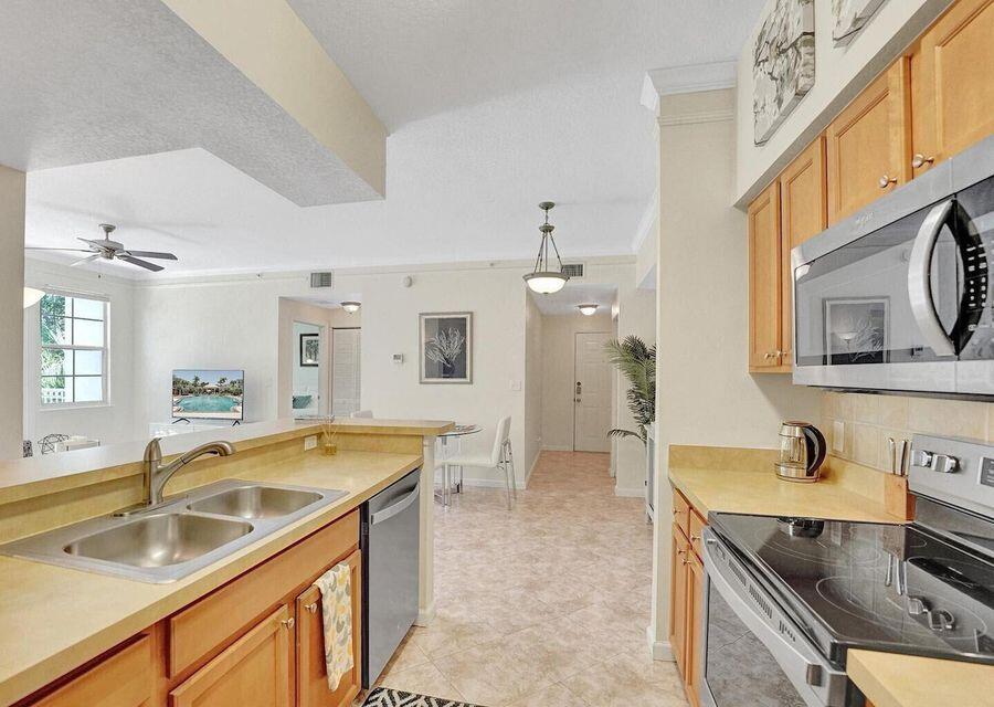9857 Baywinds Boulevard, Unit 9302 West Palm Beach, FL 33411 - Photo 19 of 45 a kitchen with a sink stove and refrigerator