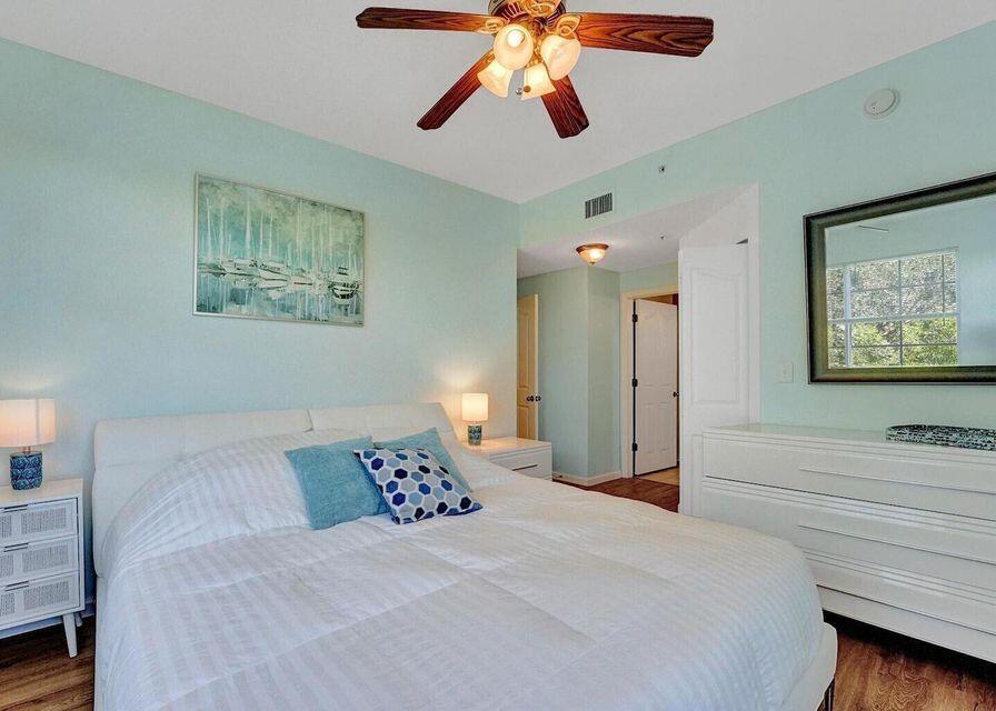 9857 Baywinds Boulevard, Unit 9302 West Palm Beach, FL 33411 - Photo 29 of 45 a bedroom with a bed and a chandelier