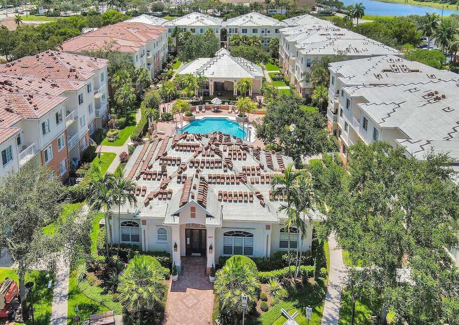 9857 Baywinds Boulevard, Unit 9302 West Palm Beach, FL 33411 - Photo 34 of 45 a front view of a multi story residential apartment building with yard and parking