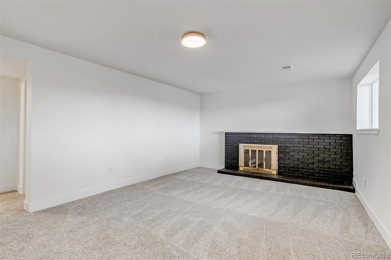 9260 Cody Lane Westminster, CO 80021 - Photo 14 of 18 a view of an empty room with a fireplace