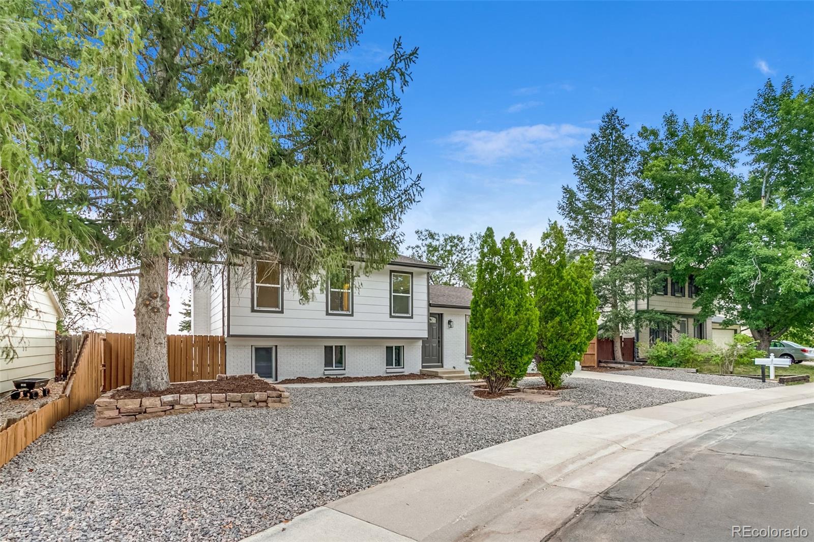 9260 Cody Lane Westminster, CO 80021 - Photo 3 of 18 a view of a house with a tree and a yard