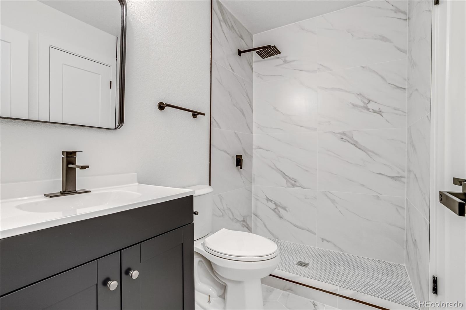 9260 Cody Lane Westminster, CO 80021 - Photo 10 of 18 a bathroom with a sink a toilet and shower
