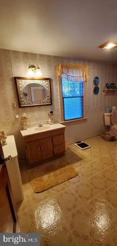 a front view of a house with yard and trees in the background