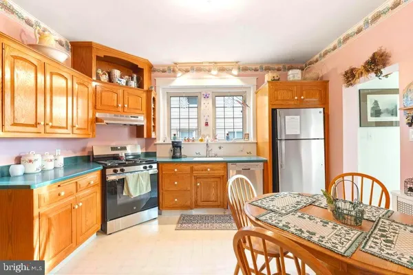 a kitchen with stainless steel appliances granite countertop a stove a sink dishwasher a dining table and chair with wooden floor
