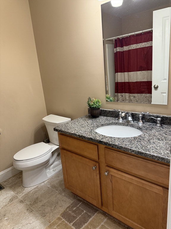 17 Lynwood Street Fall River, MA 02721 - Photo 7 of 28 a bathroom with a granite countertop toilet sink and mirror
