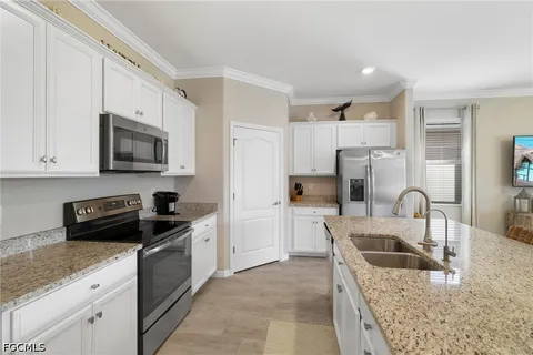 a kitchen with stainless steel appliances granite countertop white cabinets sink and dishwasher