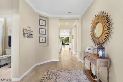 a view of a hallway with wooden floor and a potted plant