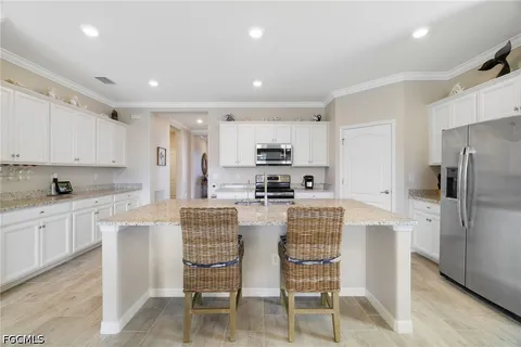a kitchen with stainless steel appliances granite countertop white cabinets a stove a sink and dishwasher