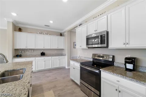 a kitchen with stainless steel appliances granite countertop a refrigerator stove microwave and sink