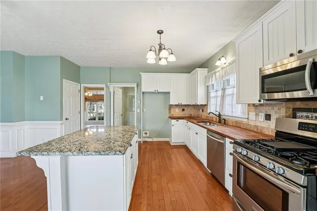a large kitchen with cabinets wooden floor and stainless steel appliances