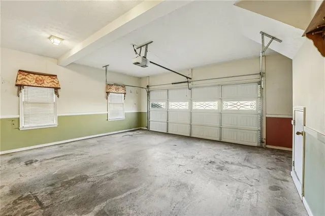 a view of a house with a small yard and large trees