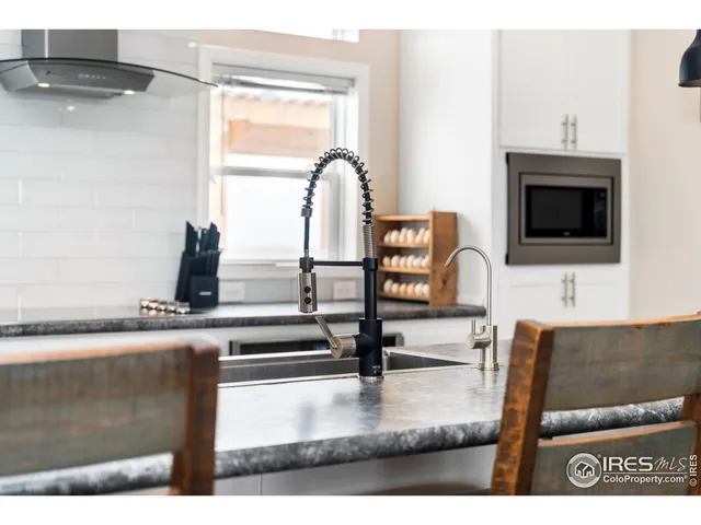 a kitchen with granite countertop a sink and cabinets