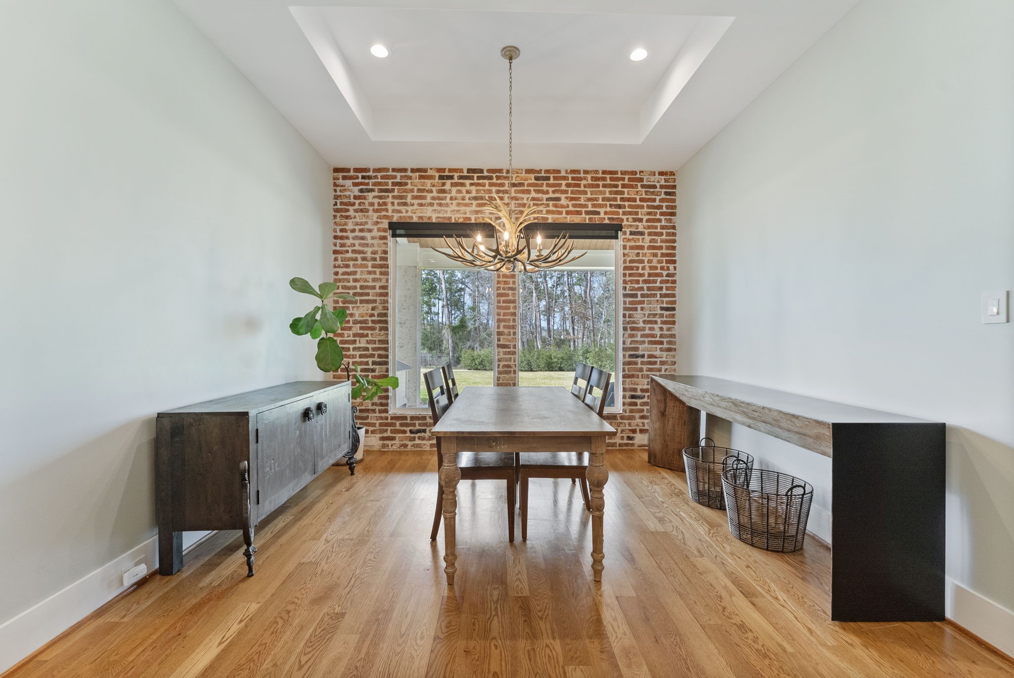 14019 Beartooth Bend Trail Conroe, TX 77384 - Photo 12 of 28 Beautiful breakfast space featuring hardwood floors, large windows, and statement brick wall and antler chandelier.