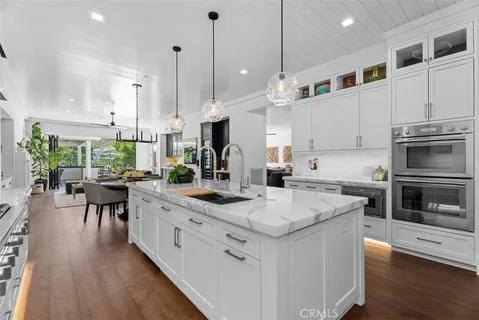 a kitchen with stainless steel appliances kitchen island granite countertop a stove a sink and a refrigerator