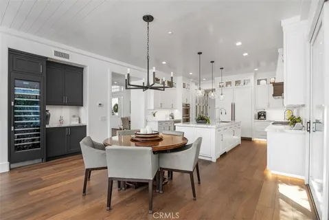 a view of a dining room and livingroom with furniture wooden floor a chandelier