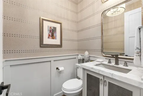 a bathroom with a granite countertop sink mirror vanity and toilet
