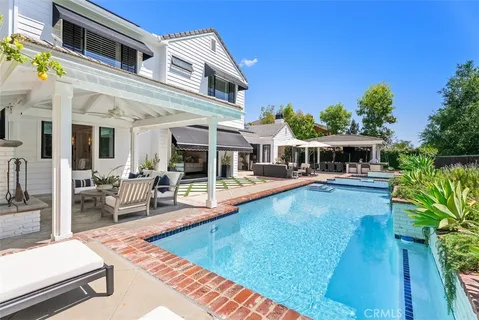 a view of house with swimming pool outdoor seating