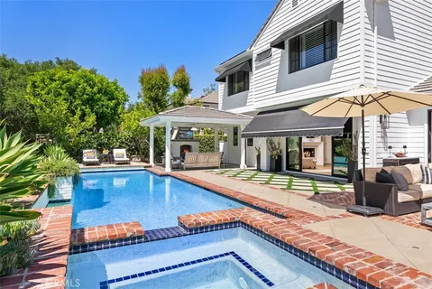 a view of a house with swimming pool and sitting area