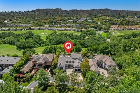 an aerial view of a house with a yard and lake view