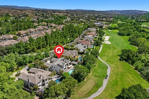 an aerial view of residential houses with outdoor space and trees