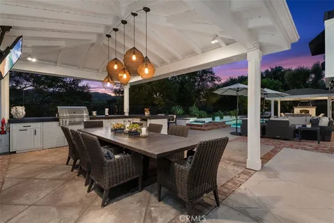 a outdoor dining area with a table a table and chairs