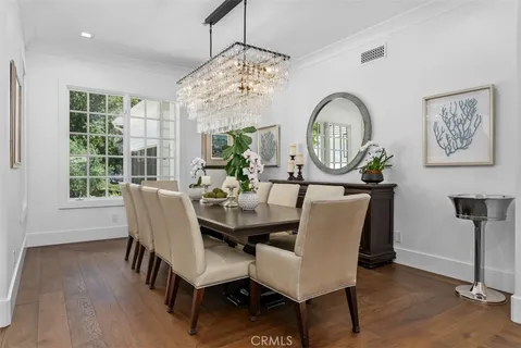 a view of a dining room with furniture a chandelier and wooden floor