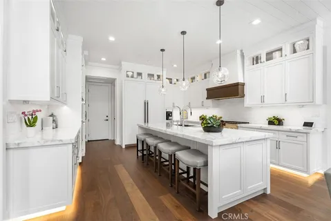a kitchen with kitchen island a white counter space a sink appliances and cabinets