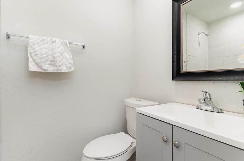 2003 West Bond Street Denison, TX 75020 - Photo 11 of 16 a bathroom with a toilet sink and mirror