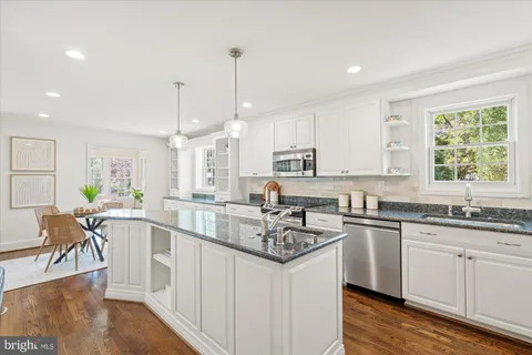 a kitchen with lots of counter top space sink stove and wooden floor