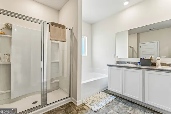 a bathroom with a tub mirror and shower