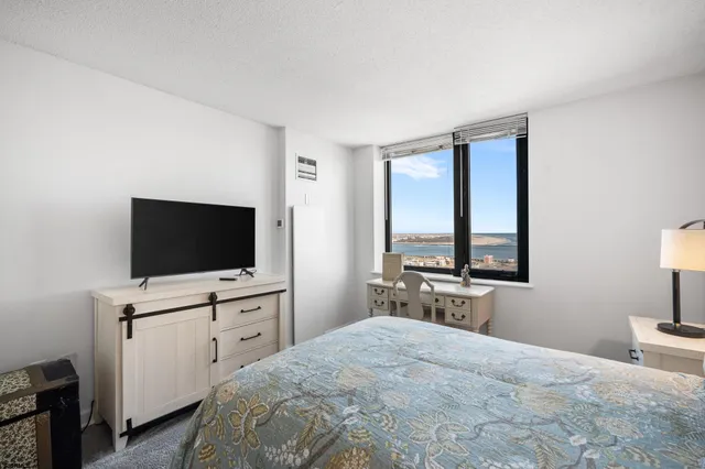 a bedroom with a bed a mirror and lamp