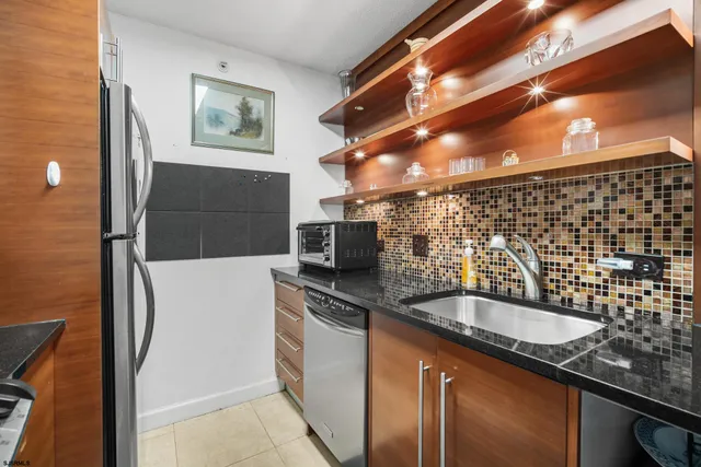 a kitchen with stainless steel appliances granite countertop a refrigerator and a stove