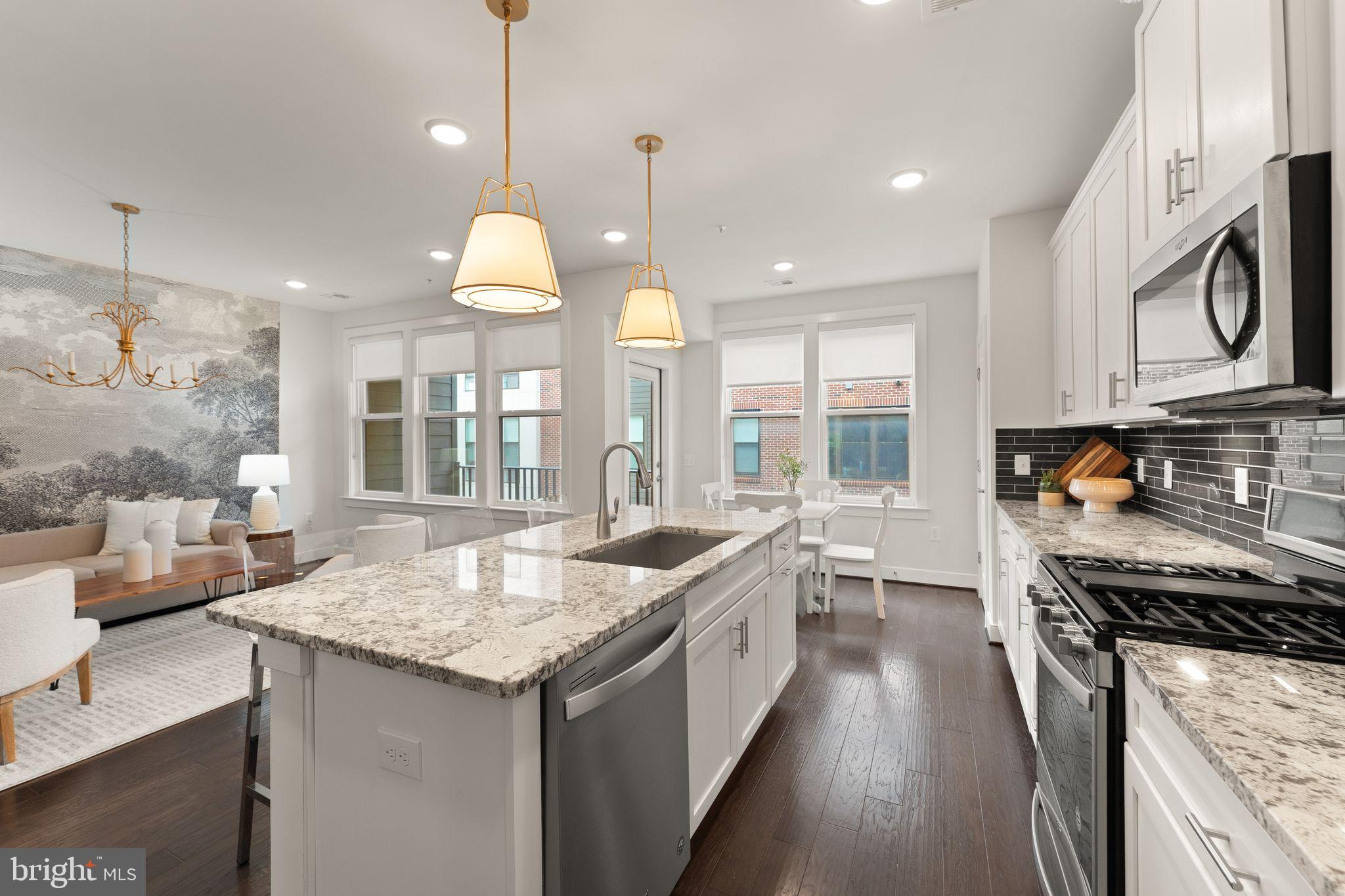 1867 Michael Faraday Drive, Unit 4 Reston, VA 20190 - Photo 15 of 53 a kitchen with granite countertop kitchen island stainless steel appliances a stove and a sink
